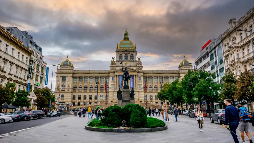 Pohled na horní část Václavského náměstí, kde je Národní muzeum. Lidé jsou okolo sochy koně.