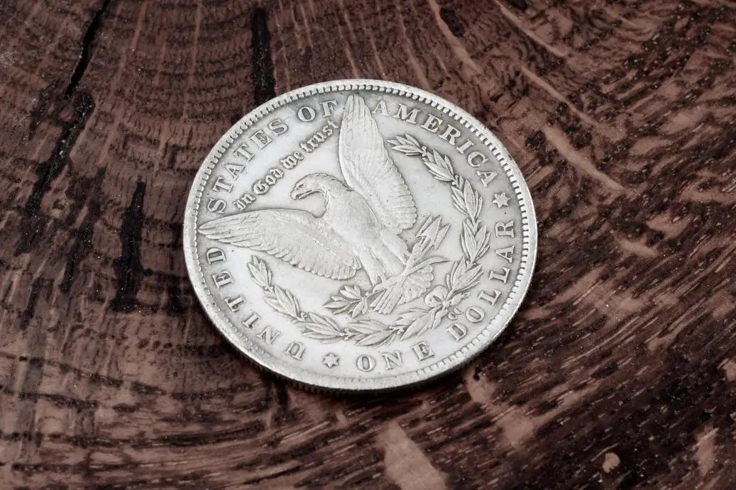 Stará americká stříbrná dolarová mince na dřevěném pozadí