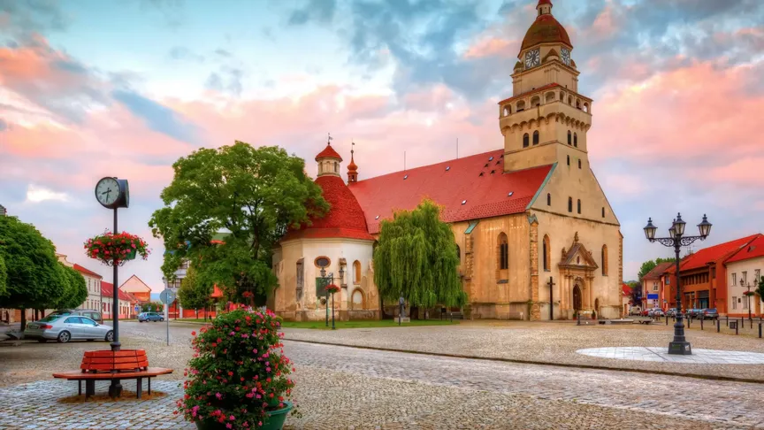 Kostel sv. Alžběty ve městě Skalica při západu Slunce. Přilehlé náměstí je liduprázdné.