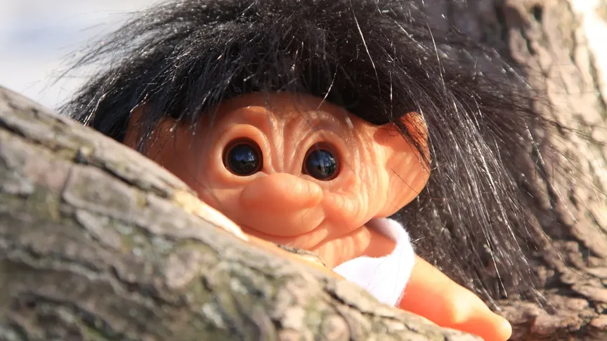 Roztomilý skřítek vykukuje zpoza stromu.