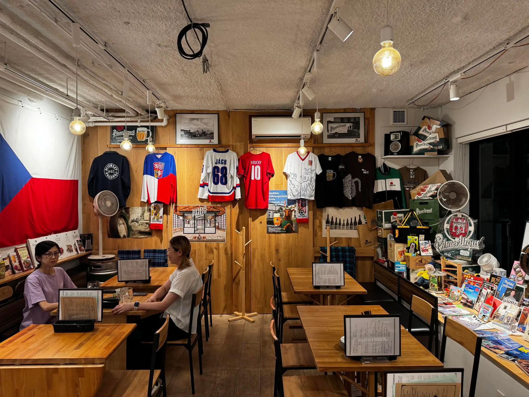 Vnitřek restaurace Pilný Piják v Tokiu. Sedí v ní dvě zákaznice.