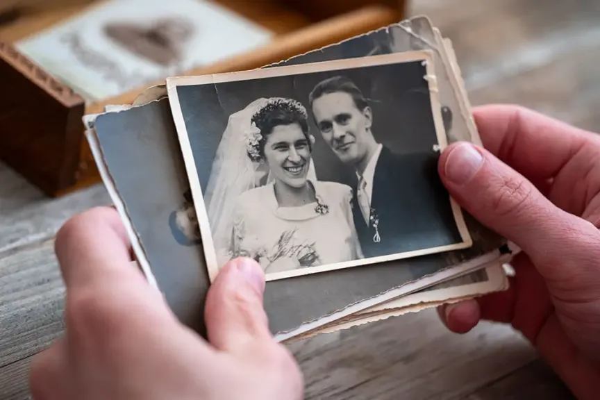 Muž si prohlíží starou svatební fotografii. 