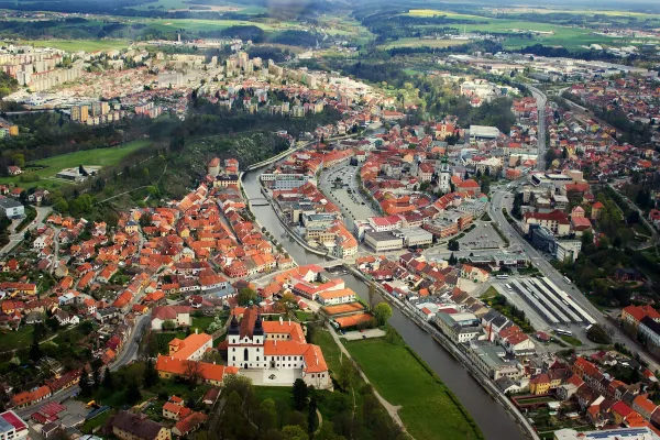 Letecký pohled na město Třebíč s viditelnými historickými stavbami a okolní přírodou.