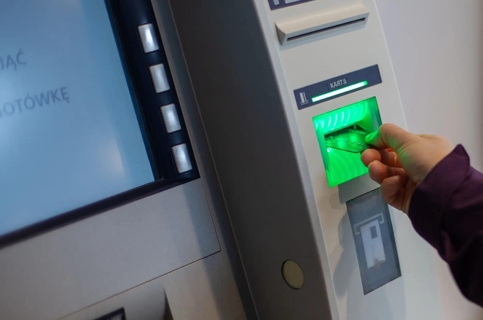 Žena vkládající platební kartu do bankomatu