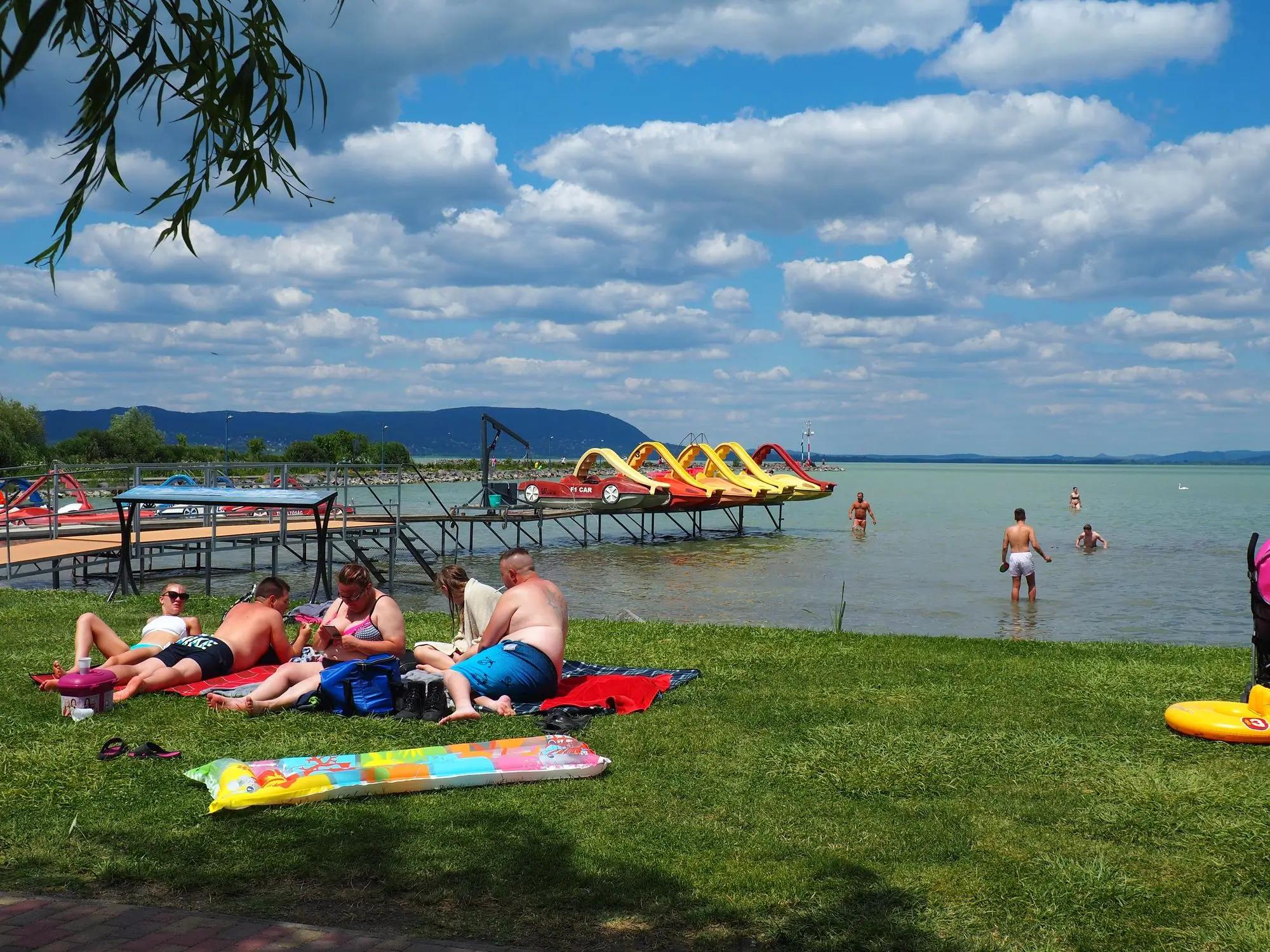 lidé leží na břehu u Balatonu