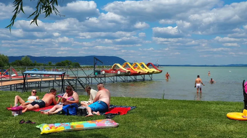 lidé leží na břehu u Balatonu
