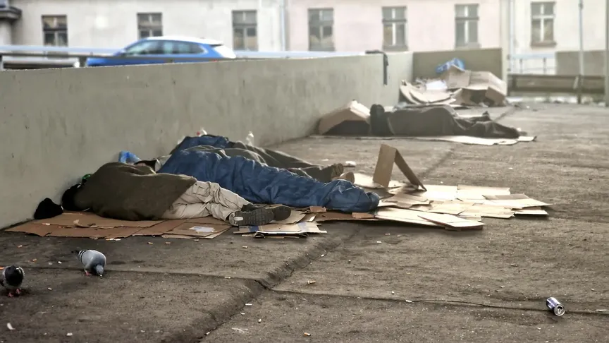 lidé bez domova spí na kartonech na ulici