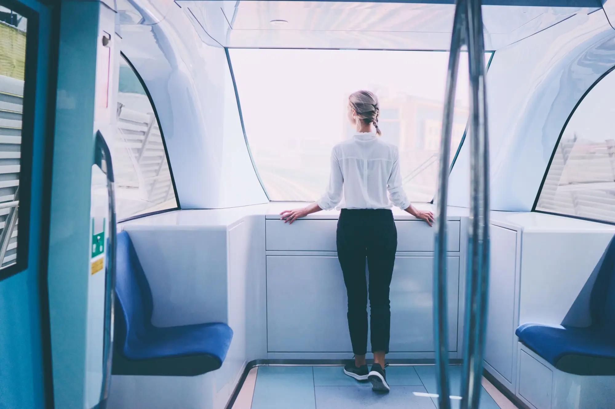 žena stojící u předního okna vlakové soupravy metra