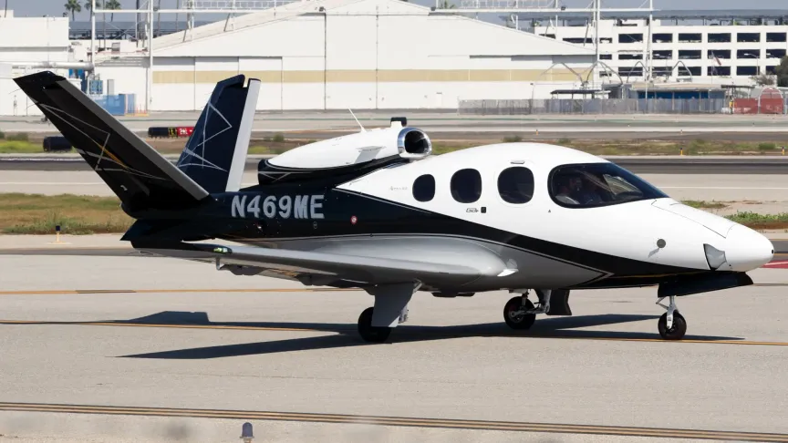 Černo-bílý letoun Cirrus Vision SF50, který stojí na letišti.