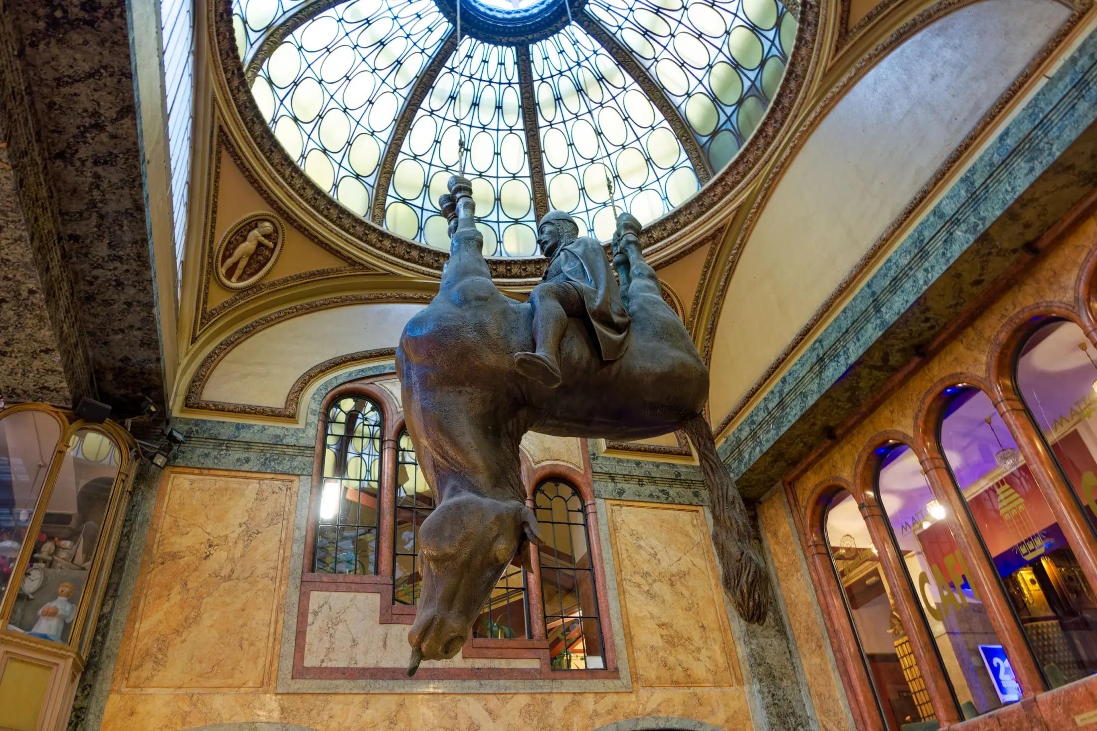 Svatý Václav, který sedí na koni. Kůň je mrtvý a visí vzhůru nohama. Dílo je v pasáži Lucerny.