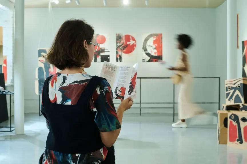 Obrázek ukazuje dívku v galerii, která si prohlíží program. Lze vidět také několik obrazů.
