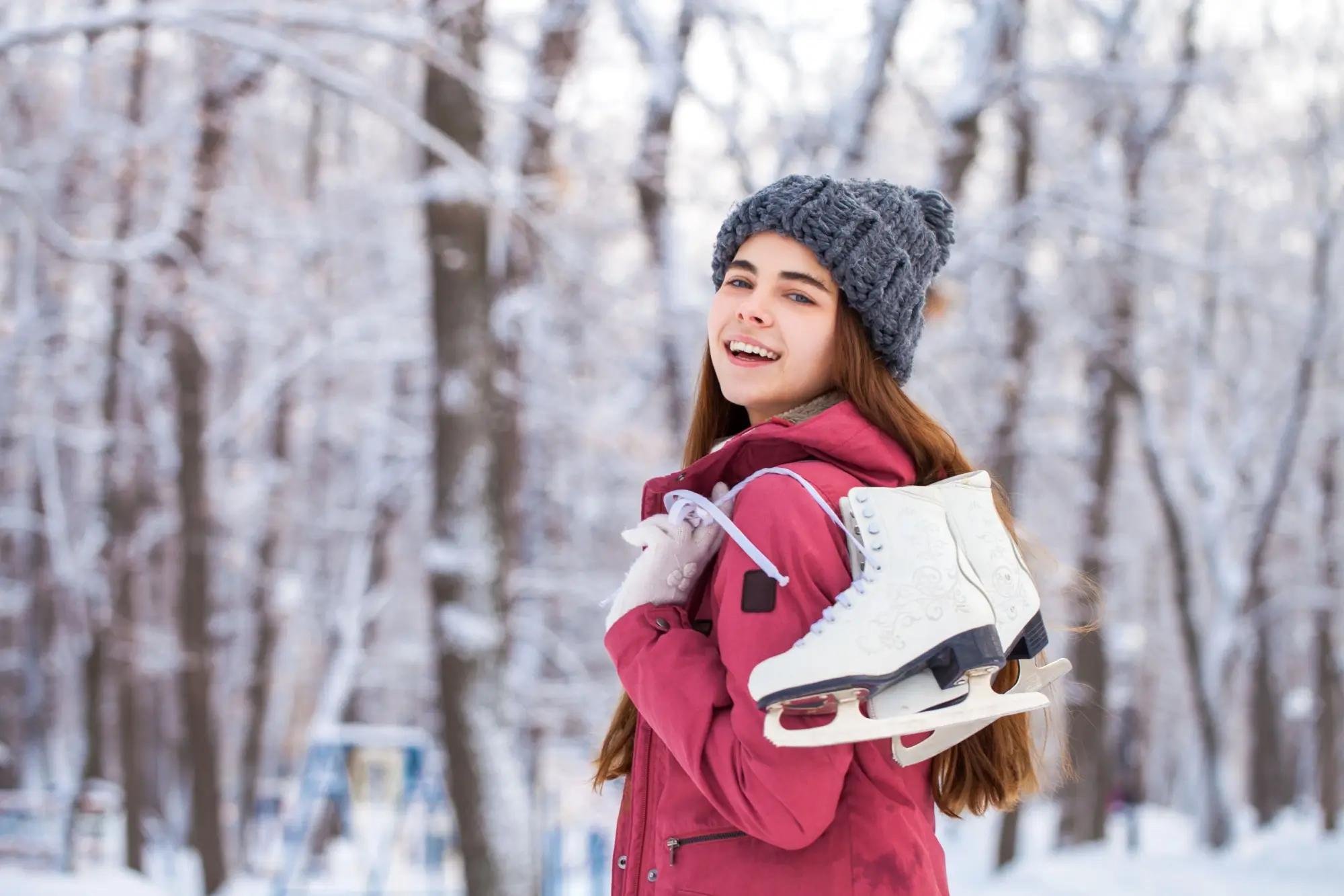 Žena venku v zimě nese zimní brusle