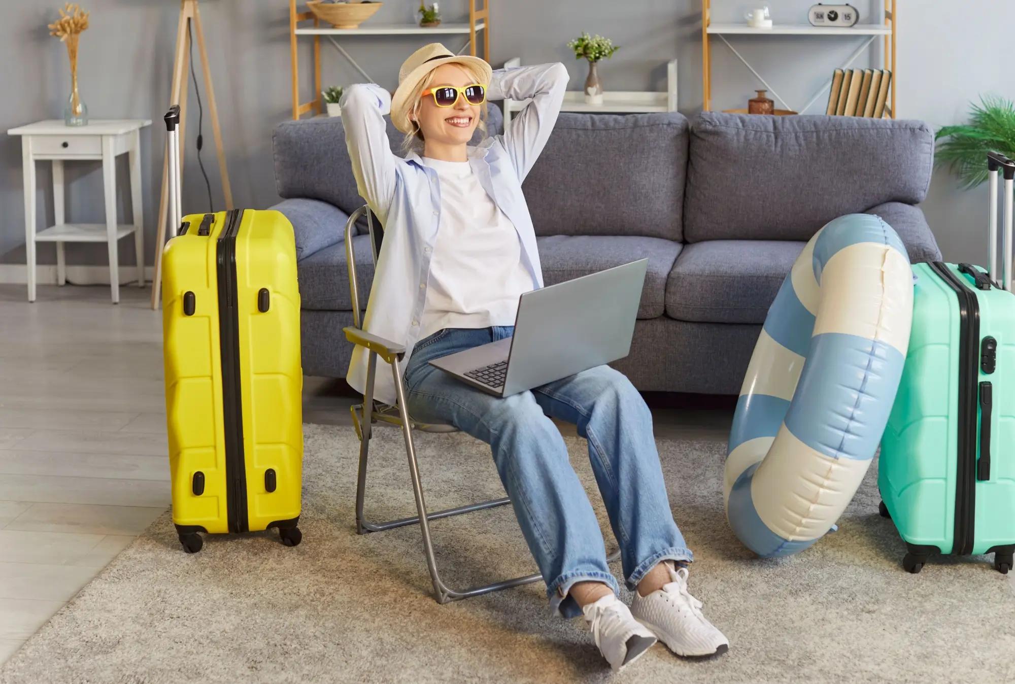 Sedící šťastná žena obklopena kufry, která se chystá na dovolenou