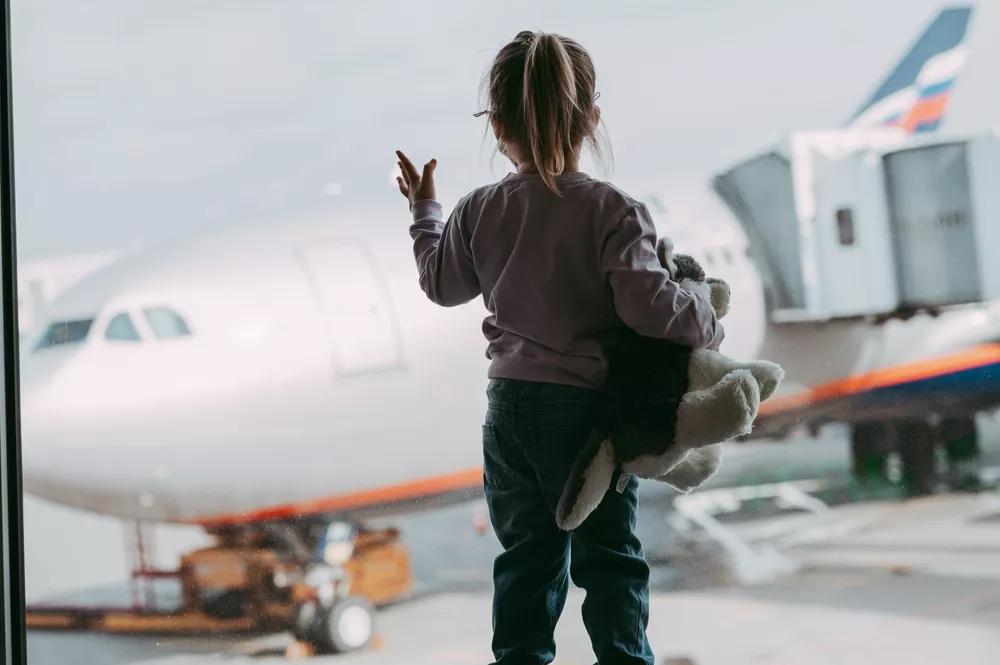 dítě s plyšákem při nástupu do letadla