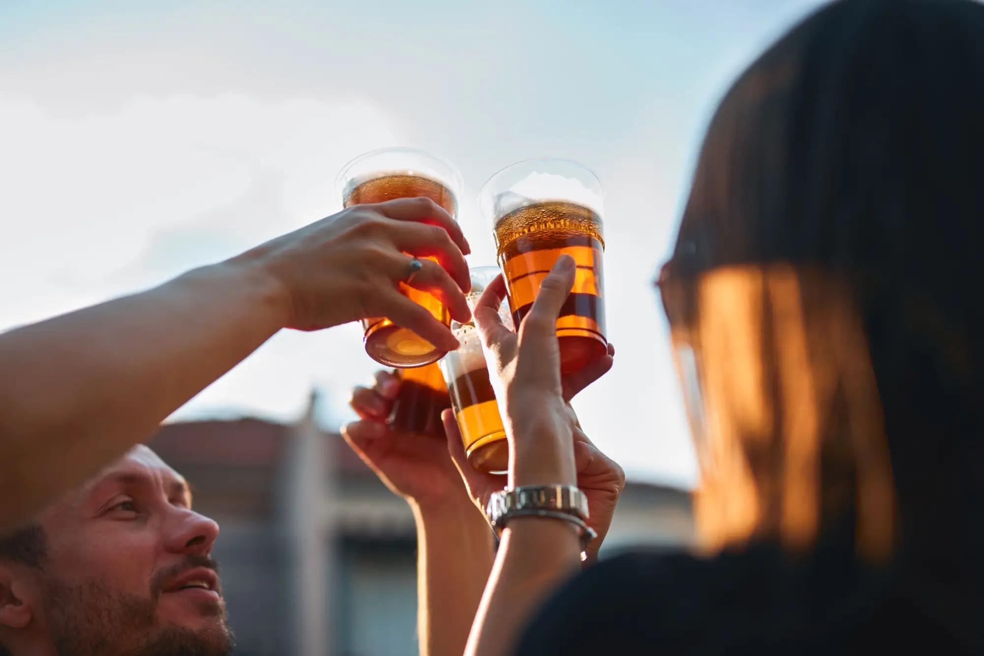 muž si prohlíží sklenici s pivem