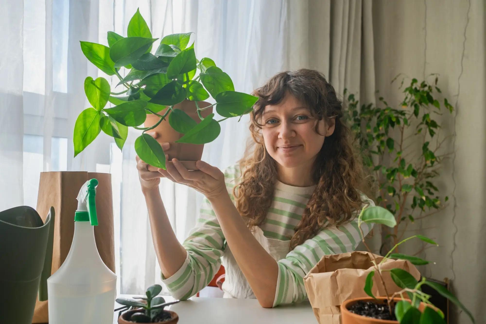 Dívka s pokojovou rostlinou Pothos. Zdroj: shutterstock.com