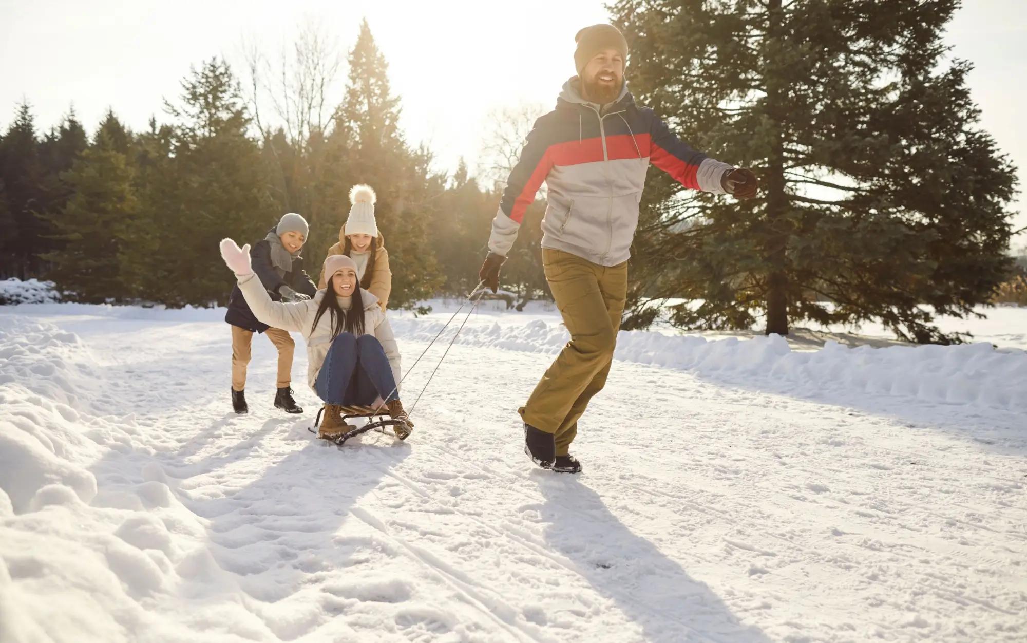 Rodina v zimě sáňkuje