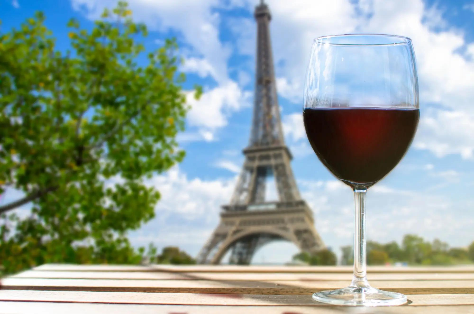 sklenice červeného vína před Eiffelovkou