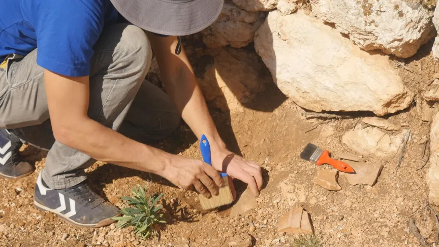archeolog pracuje při vykopávkách se štětcem