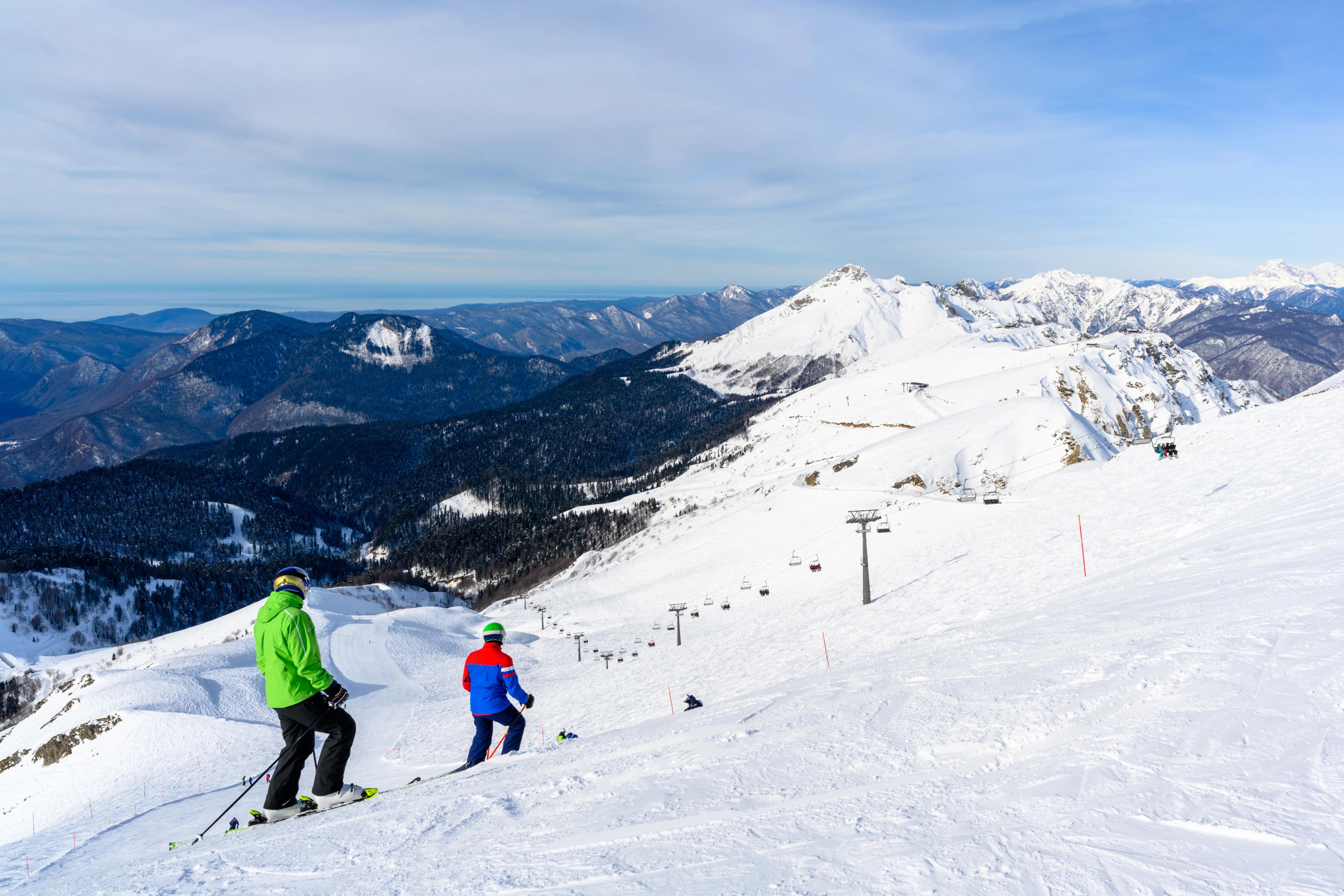 Výhled na horskou sjezdovku s lyžaři.