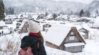 Žena se dívá na zasněženou vesnici