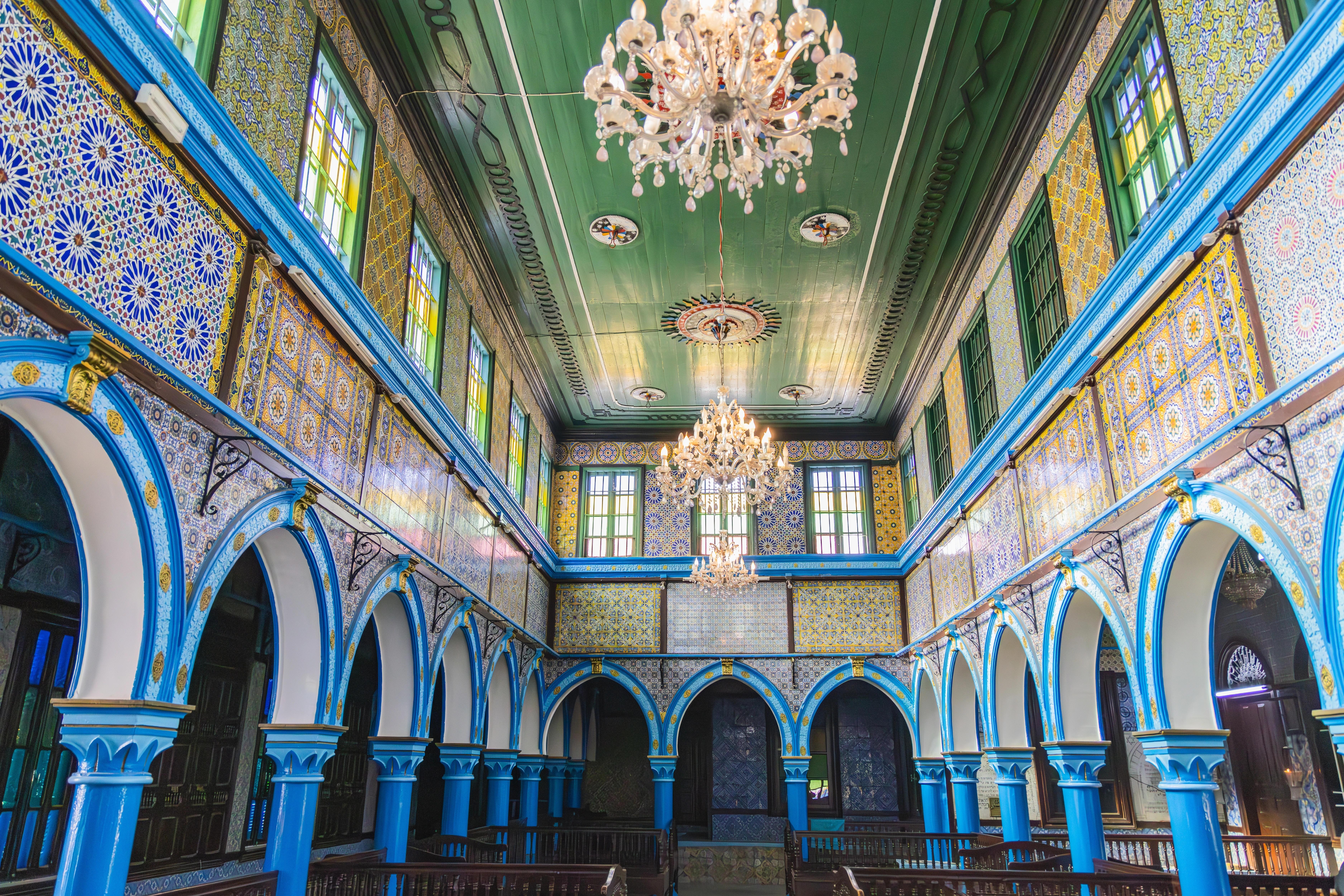 Vnitřní pohled na barevnou synagogu El Ghriba v maurském stylu a s rozsvícenými lustry. Djerba, Medenine, Tunisko. Zdroj: Shutterstock