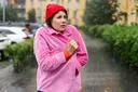 Žena v čepici choulící se do bundy