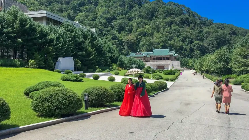 Severní Korea, turistická oblast, v popředí ženy v tradičním oděvu.