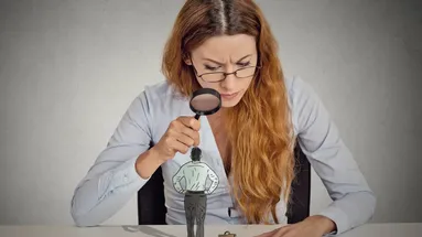 žena kouká přes lupu