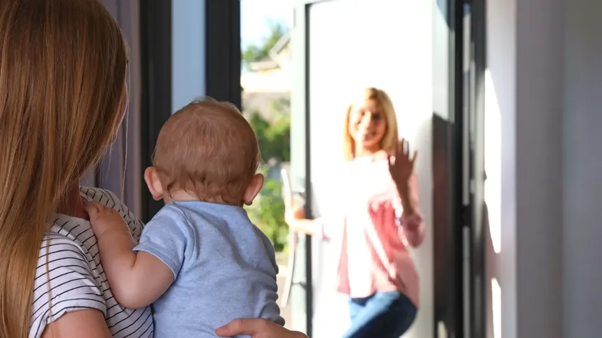 Mladá žena nechává své dítě, nejspíše jen pár měsíců staré, v rukách au pair. Odchází z domu a z otevřených dveří jim mává.