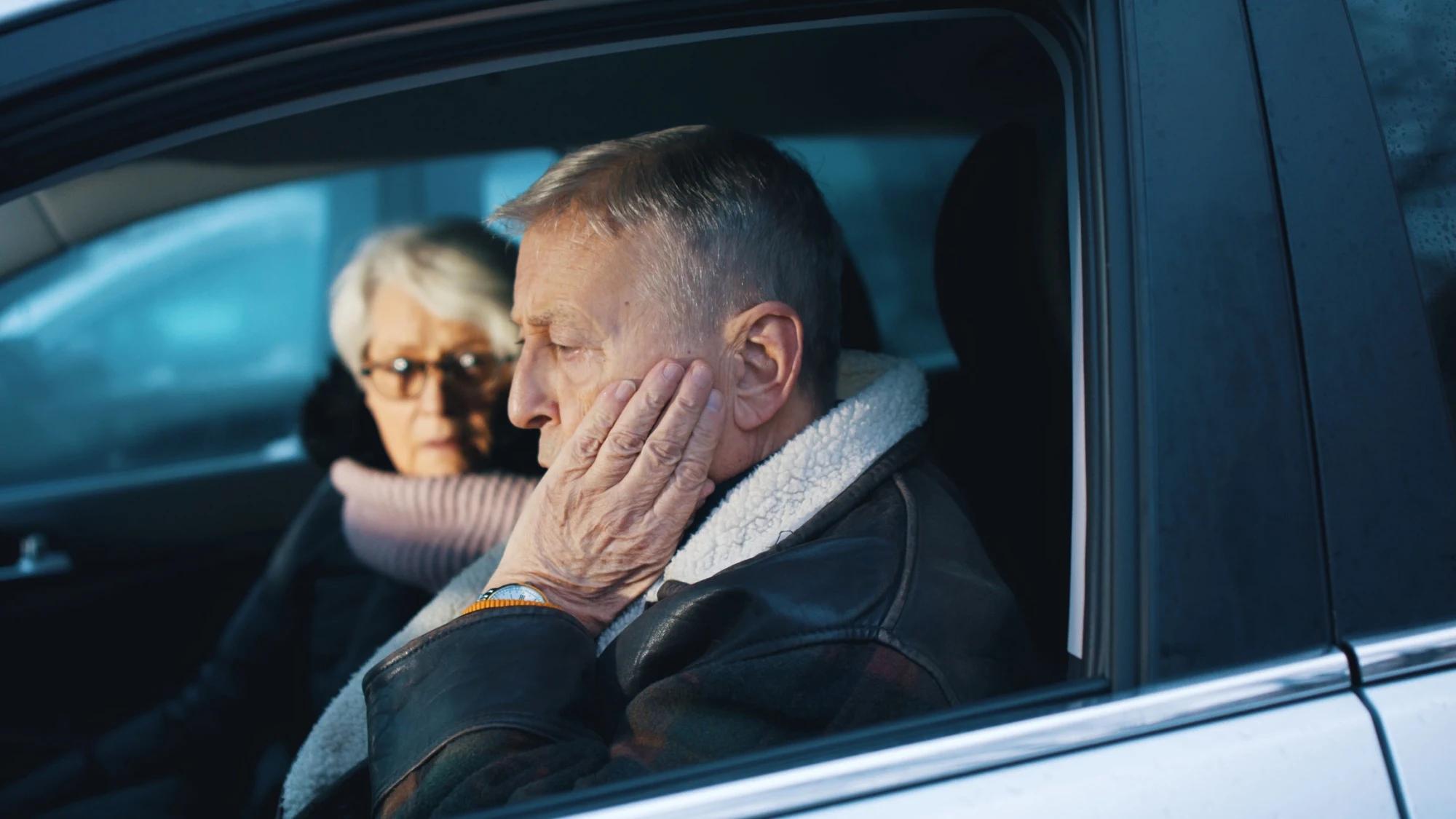 Muž je zmatený za volantem, žena mu vysvětluje, co se za jízdy stalo