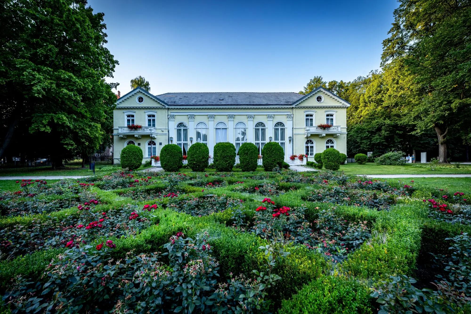 rozkvetlá zahrada, před budovou termálních lázní