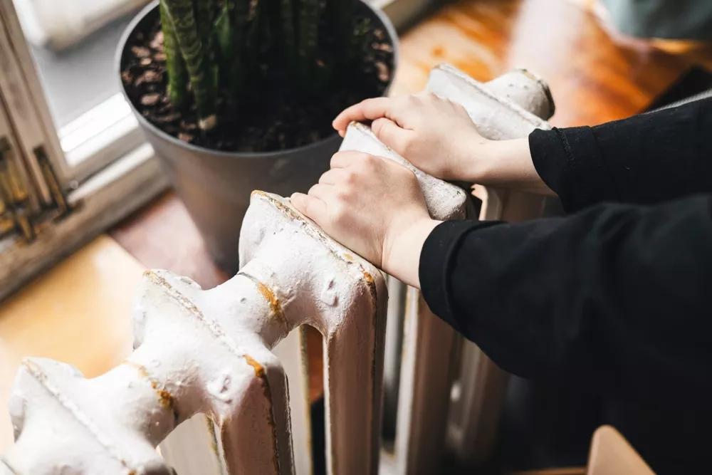 Žena kontrolující topení