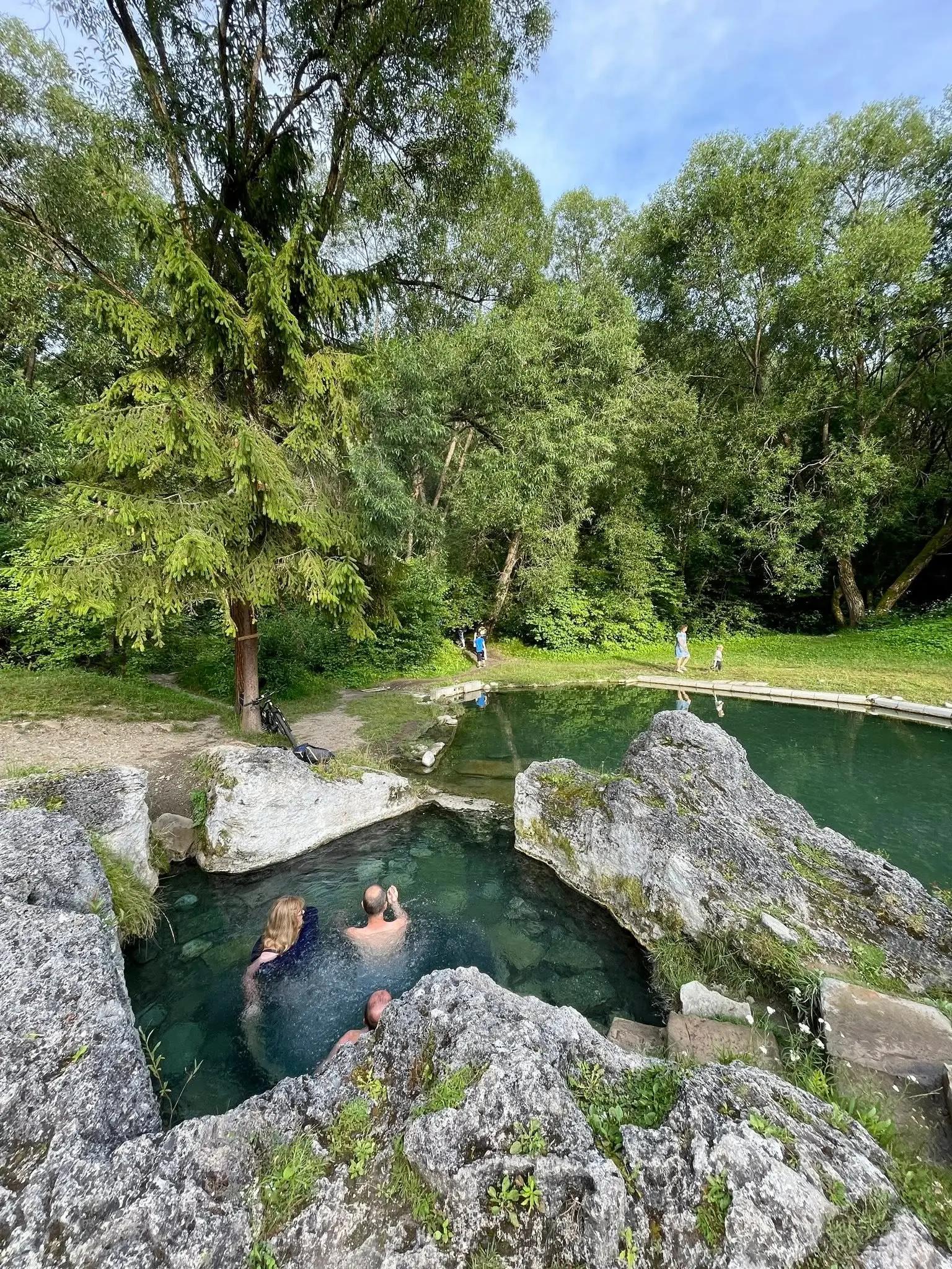 Lidé koupající se v Kadě, v pozadí bazének