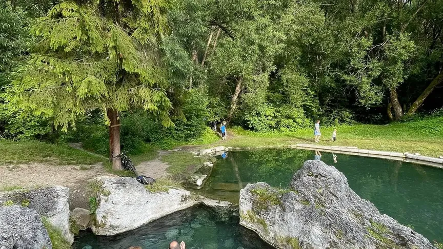 Lidé koupající se v Kadě, v pozadí bazének