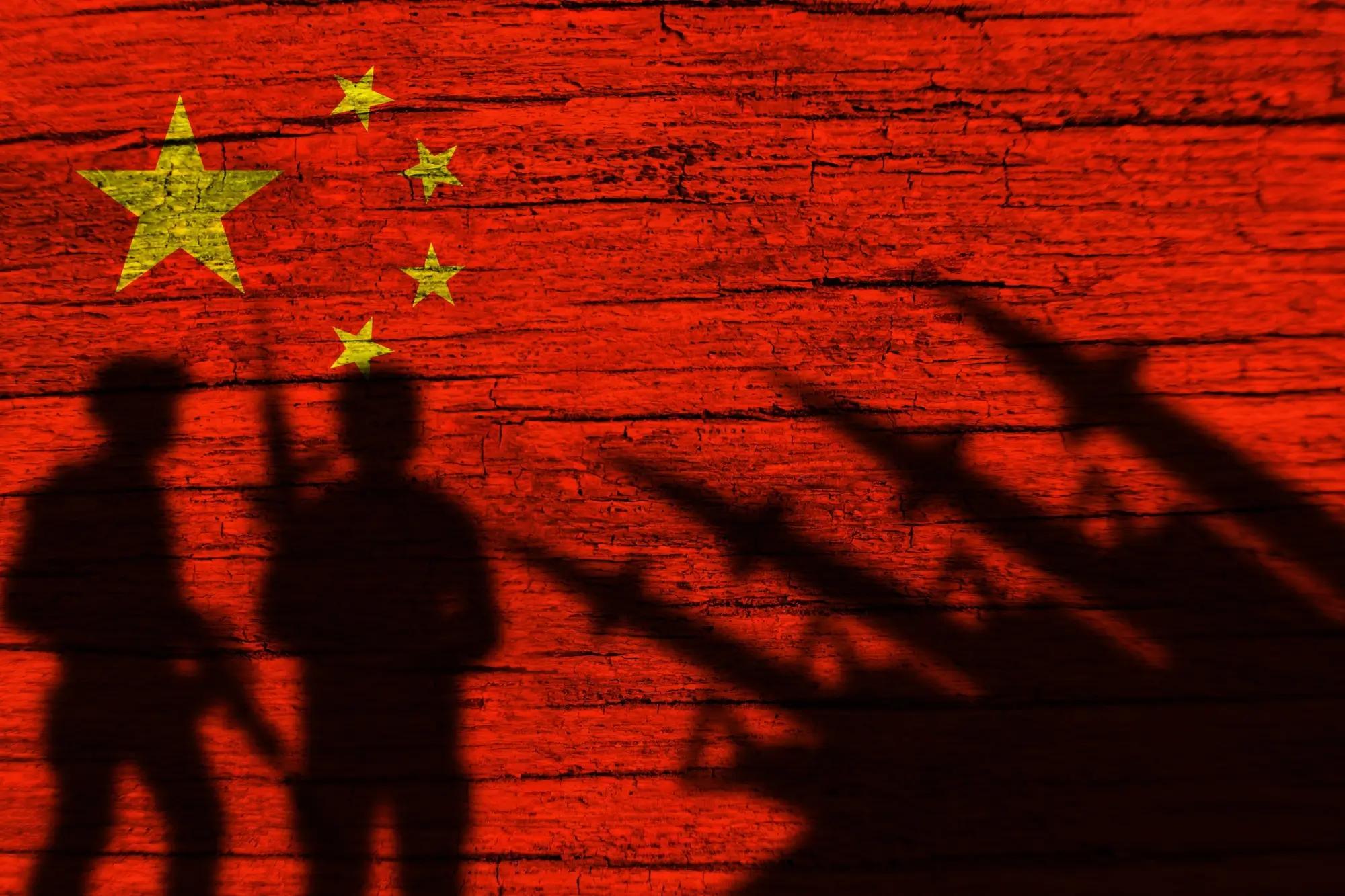 Siluety vojáků a zbraní na čínské vlajce