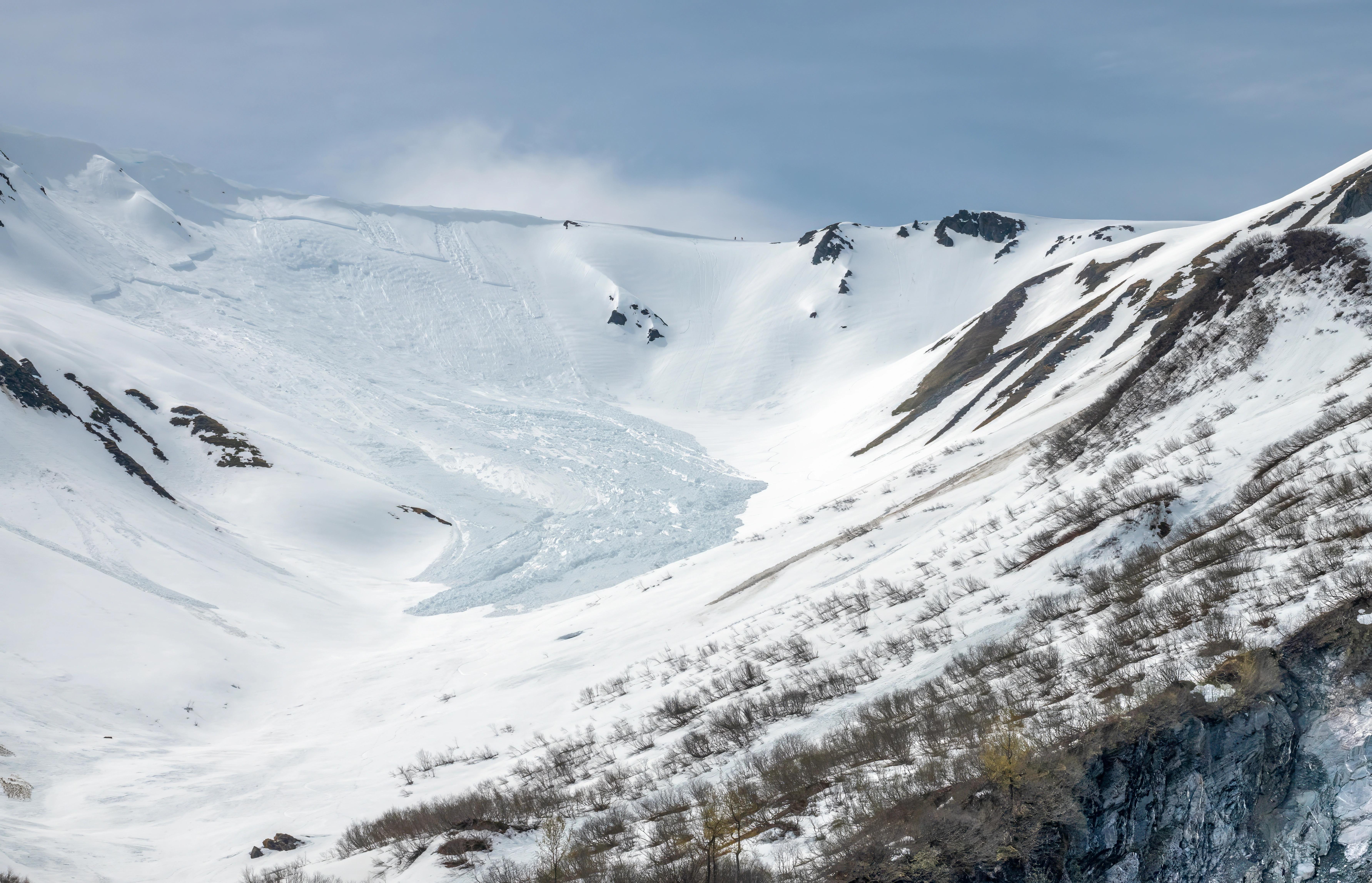 Zasněžená hora, na kterou se valí lavina.