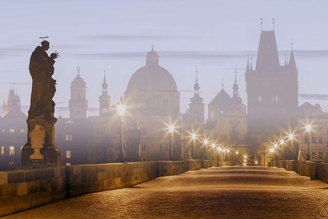 Pohled za šera na rozsvícený Karlův most.