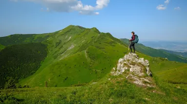 turista stojící na vrcholku pohoří