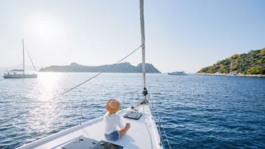 Luxusní cestování na jachtě. Mladá šťastná žena na palubě lodi plující po moři. Jachting v Řecku