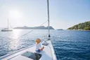 Luxusní cestování na jachtě. Mladá šťastná žena na palubě lodi plující po moři. Jachting v Řecku