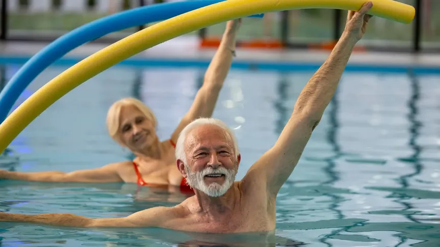 senioři v bazénu cvičí na pokyn pracovnice lázní
