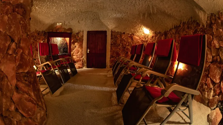 Obrázek ukazuje solnou jeskyni s lehátky, kde pacienti mohou odpočívat.