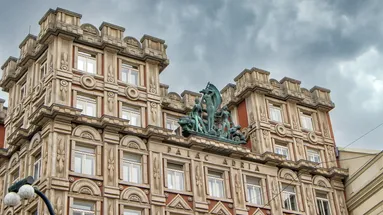Fotka paláce Adria za mračného dne.
