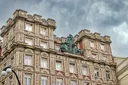 Fotka paláce Adria za mračného dne.