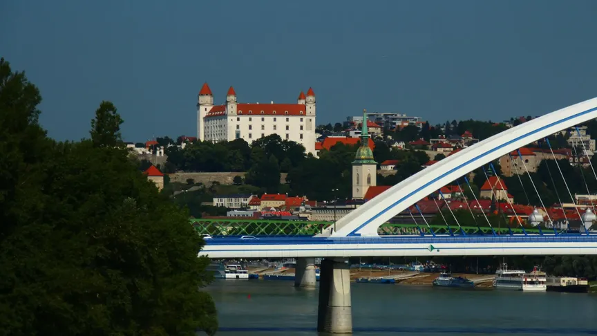 Letecký záběr na Bratislavu. Vidět jde řeka, přes kterou vede most a trochu v dálce Bratislavský hrad.