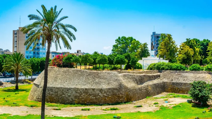 Benátské opevnění ve městě Nikósie. Je krásný den, modrá obloha bez mráčků. V okolí jsou vidět zelené stromy.