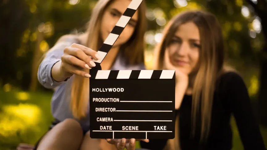 dívka drží v ruce filmovou klapku