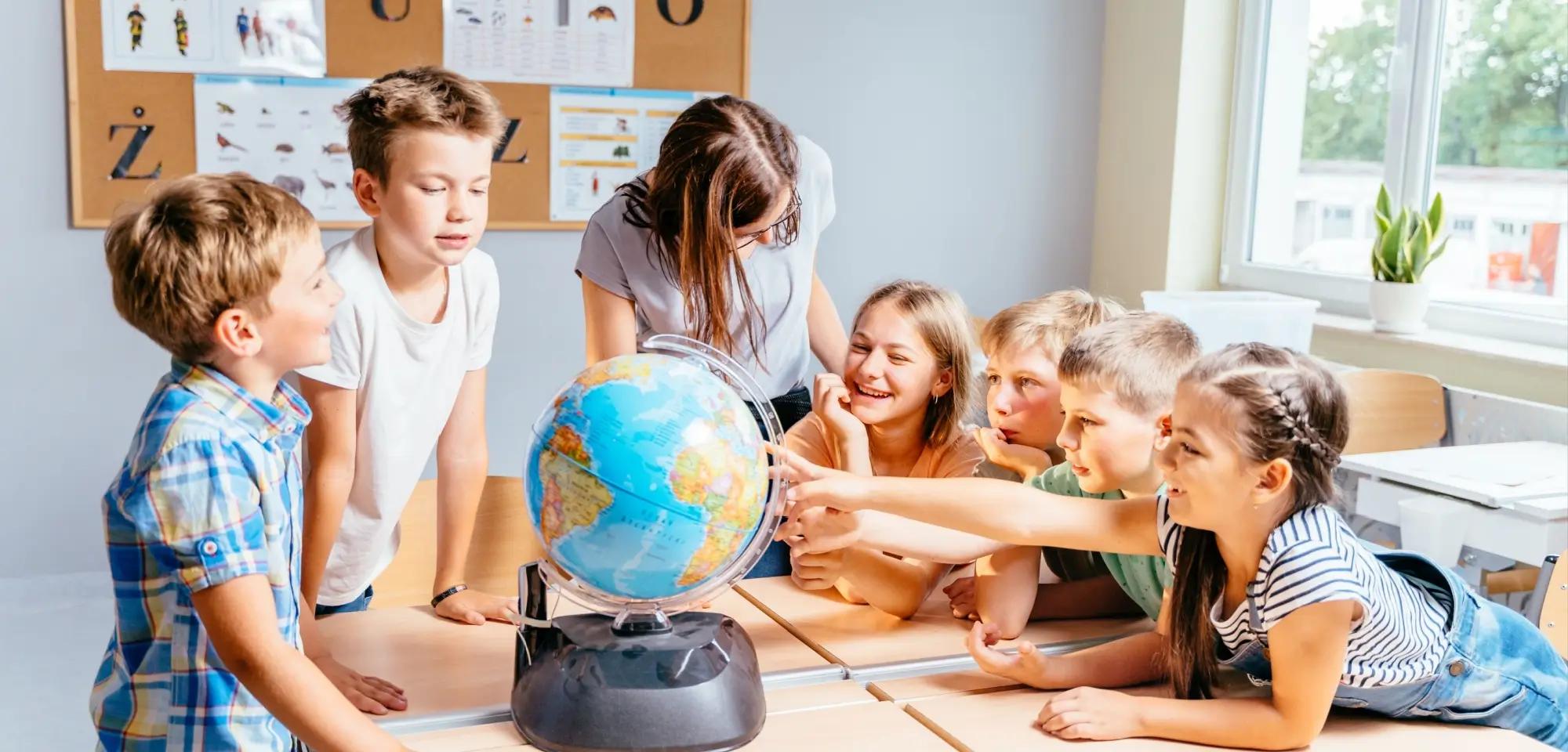 Děti ukazují na globus. 