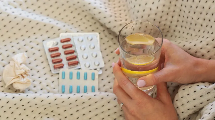 Na obrázku jsou léky, spolu s vodou.